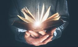 Man holding and reading the Holy Bible or a hard cover book concept for religion or study