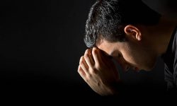 Young man praying in the dark