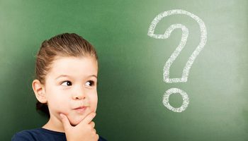 little student in front of the blackboard with question mark