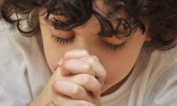 A boys prays earnestly to his creator in heaven