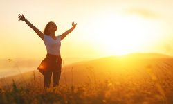 Happy woman   on sunset in nature iwith open hands